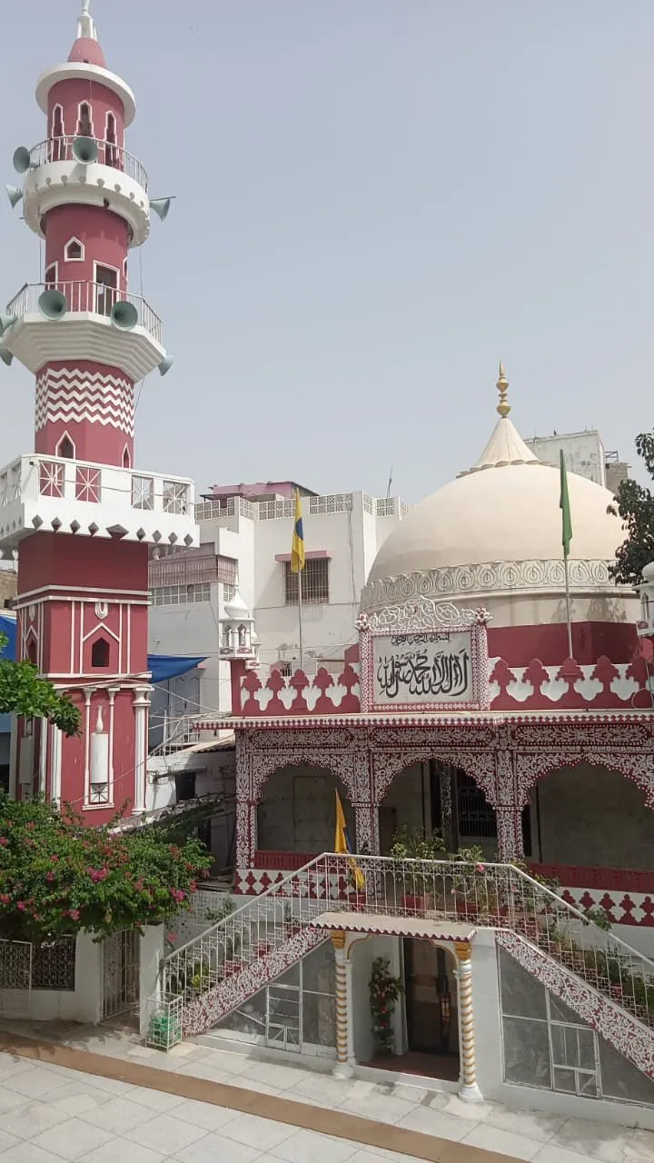 De markaz: het rood-witte gebouw met minaret, koepel en de trap naar de entree.